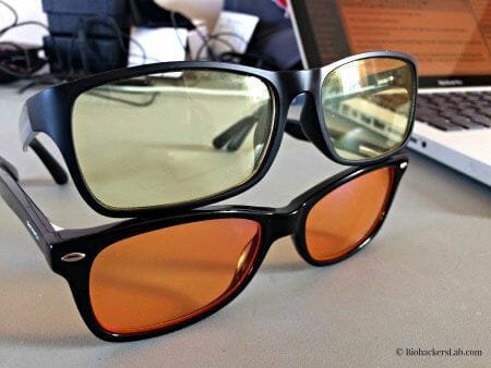 Two pairs of glasses with an orange lens and yellow lens