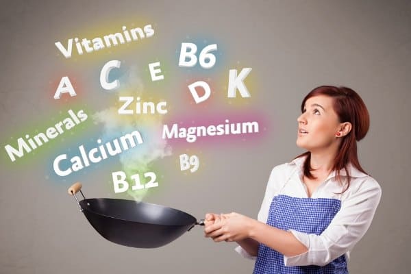 Women with a pan looking at common names for vitamins and minerals