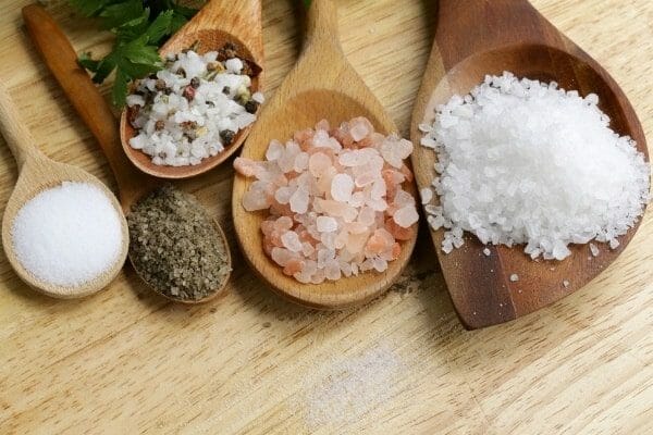 Different natural salts on wooden spoons