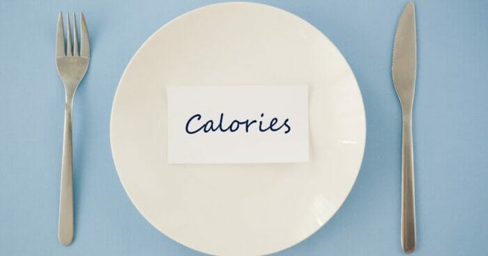 Knife and fork with a plate describing calories being restricted