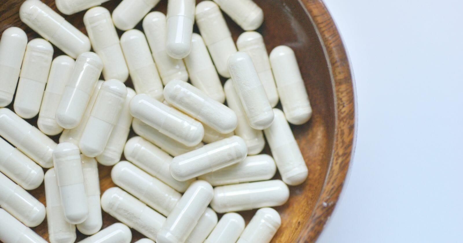 Bowl of white capsule supplements